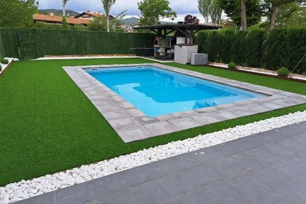 Césped artificial en jardín con piscina